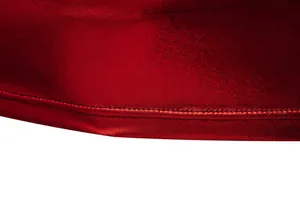 Close-up detail of shiny red fabric with high-quality double stitching on the hem.