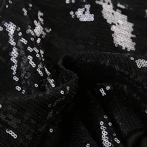Detailed macro view of high-quality shimmering black sequin fabric for fashion shorts