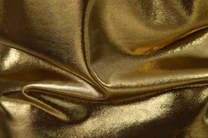 Detailed close-up showing the shiny gold metallic fabric texture and luster of a party shirt.