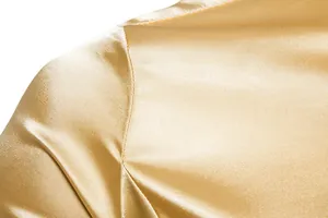 Primer plano del hombro de una camisa de satén dorado para hombre con costuras detalladas.