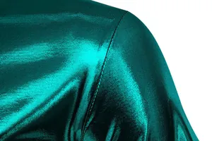 Macro close-up view of shiny metallic green fabric and stitching on a men's fashion t-shirt
