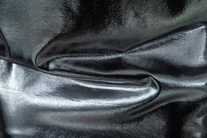 Macro close-up of shiny black metallic fabric texture for men's stage performance T-shirt
