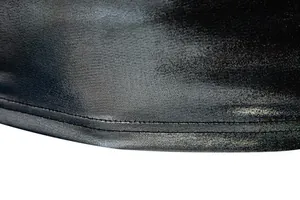 Close-up of black shiny metallic fabric hem showing fine double-stitch detail.