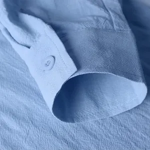 Macro-detailweergave van de manchet van een lichtblauw katoenen linnen overhemd met knoop