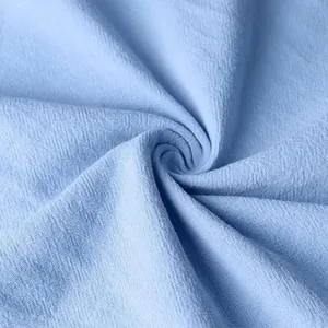 Detail macro-opname van de ademende blauwe katoen-linnen stoftextuur van het overhemd.