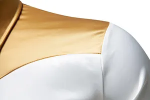 Primo piano del liscio tessuto di raso su una camicia da uomo bicolore oro e bianco