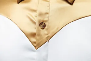 Dettaglio di una camicia in raso da uomo con bottone e cucitura bicolore