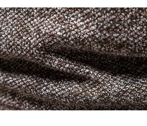 Close-up detail of thick brown and white knitted wool fabric texture for men's winter cardigan