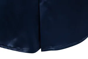 Primo piano delle cuciture dell'orlo e dello spacco laterale di una camicia in raso blu navy da uomo
