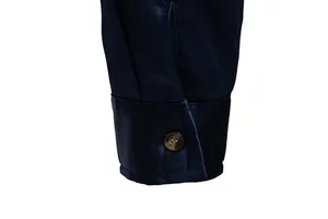 Dettaglio del polsino di una camicia di raso blu navy con bottone marrone e trama liscia.