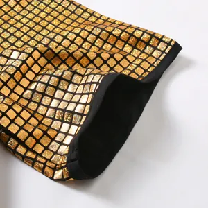 Macro detail of gold checkered shiny shirt fabric with black hemmed edge texture