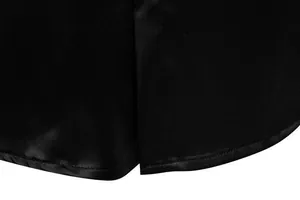 Dettaglio macro dello spacco laterale e dell'orlo liscio di una camicia in raso nero da uomo