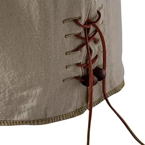 Dettaglio dell'allacciatura laterale con perline di legno su una camicia di lino da uomo