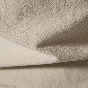Dettaglio macro della trama in tessuto traspirante beige tipo lino per camicia da uomo