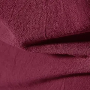 Dettaglio ravvicinato della trama traspirante in lino bordeaux per camicia casual da uomo.