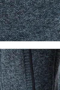Makroansicht des blau strukturierten Strickstoffs und der Rippendetails an der Herrenjacke.