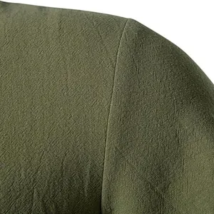 Vista macro della trama del lino verde militare e cuciture dettagliate sulla spalla.