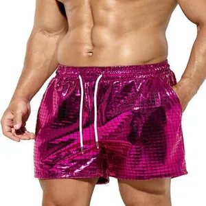 Detailed view of men's shiny pink metallic checkered beach shorts with white drawstring.