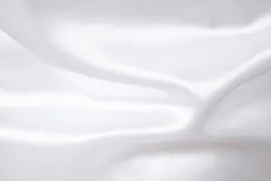 Primer plano de la textura suave y el brillo de la tela de satén blanco para camisas