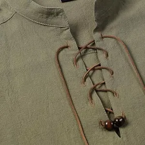 Macro view of men's linen henley shirt showing lace-up neckline and wooden beads.