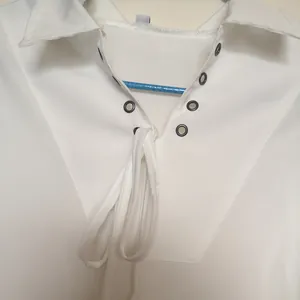 Close-up detail of medieval men's retro white shirt with lace-up neckline and metal eyelets