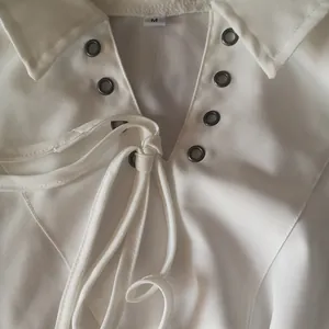 Detailed macro view of a white medieval men's shirt with lace-up collar and eyelets