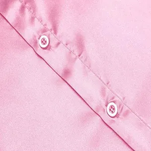 Detailopname van witte knopen op de glanzende roze satijnen stof van het discohemd