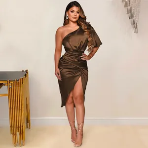 Detailansicht eines braunen Satin-Einschulter-Midikleids mit elegantem hohem Beinschlitz.