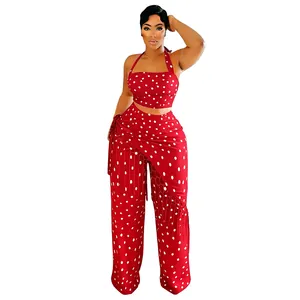 Détail d'un ensemble deux pièces pour femme rouge à pois avec crop top et pantalon à franges.