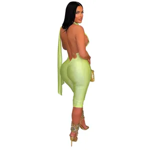 Rear view of a sexy lime green backless bodycon jumpsuit modeled on a white background
