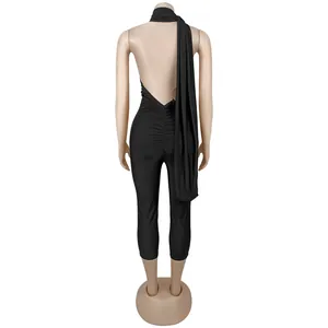 Back view of a black backless halter jumpsuit featuring a stylish long drape detail