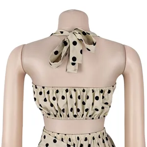 Vue détaillée du haut dos nu beige à pois noirs avec nœud à l'arrière sur mannequin.