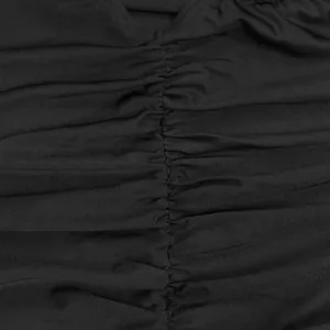 Detailed macro view showing the fine ruched center seam on a black fashion bodysuit