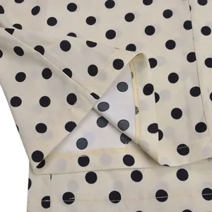 Gros plan détaillé montrant l'ourlet et la texture du tissu à pois d'un pantalon large fluide