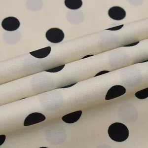 Vue détaillée d'un tissu blanc cassé léger avec un motif à pois noirs classique