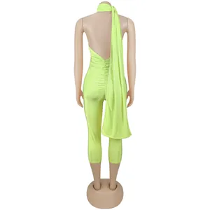 Back view of a lime green backless jumpsuit with elegant drape detail on mannequin