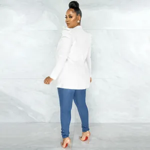 Back view of a chic white pleated sleeve blazer paired with blue jeans and high heels.