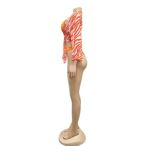 Side view detail of a sexy orange bikini with a zebra print mesh cover-up three-piece set