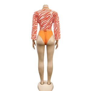 Detailed back view of a sexy 3-piece orange bikini set with zebra print mesh cover-up top