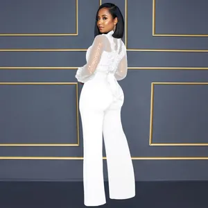 Combinaison élégante en dentelle blanche à manches longues et pantalon large pour femme.