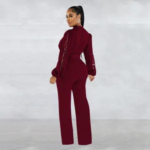 Elegant back view of burgundy long sleeve jumpsuit featuring lace hollow out sleeves and matching belt
