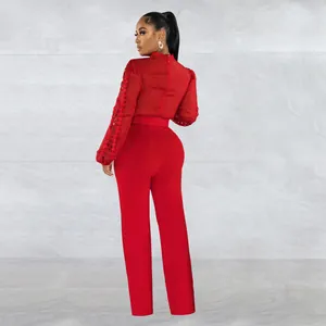 Back view of an elegant red long sleeve jumpsuit with lace hollow-out sleeve details.