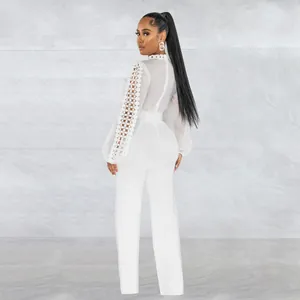 Elegant white long sleeve jumpsuit featuring intricate lace hollow-out sleeve detailing.