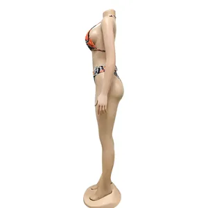 Detailed side view of a sexy abstract orange and black patterned bikini set on mannequin