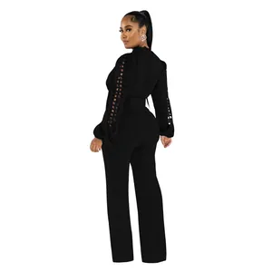 Elegant black long-sleeve jumpsuit featuring intricate lace cut-out details on sleeves.