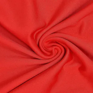 Makro-Detailaufnahme von leuchtend rotem Strickstoff mit detaillierter Textur und Maschenbild