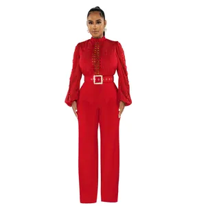 Elegant red long sleeve jumpsuit featuring hollow-out lace details and a matching belt.