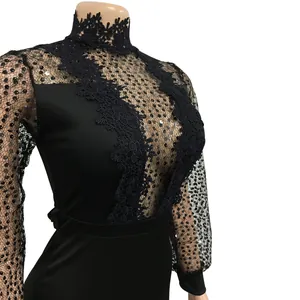 Détail d'une combinaison noire en dentelle et paillettes avec manches longues en maille