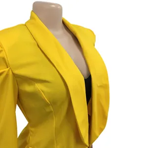 Detail view of a vibrant yellow long sleeve blazer with pleated shoulder design.