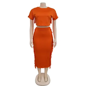 Zweiteiliges Set in hellem Orange mit Fransen-Crop-Top und passendem Midirock-Detail.